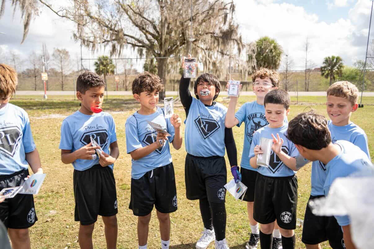 Coach and kids holding trading cards